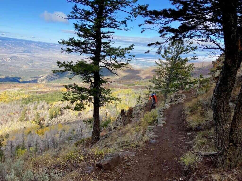 Mountain biker riding down switchbacked trail on Palisade Plunge in Colorado