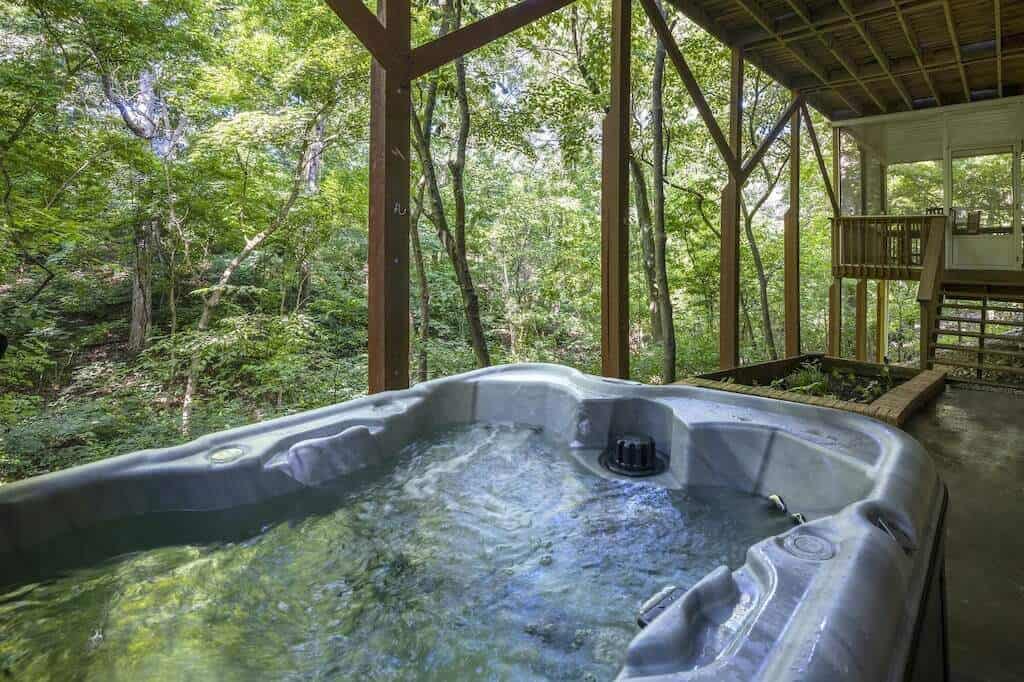 Hot tub on deck looking out over lush green forest in Bentonville, Arkansas