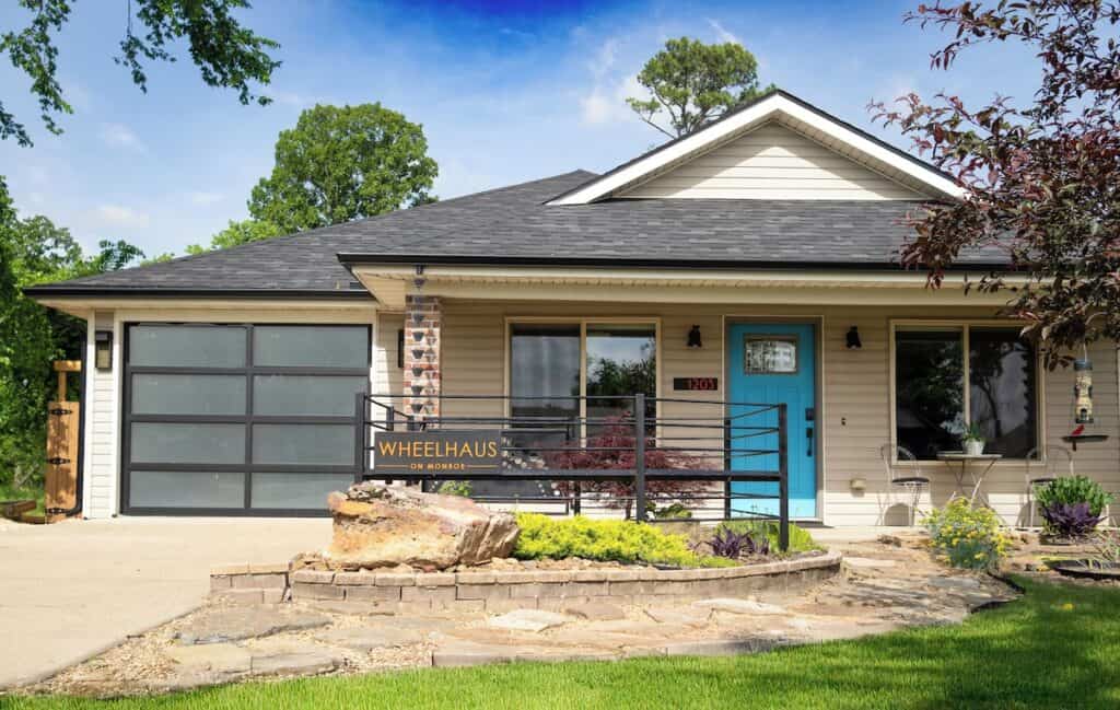 a house with a blue door and a black fence