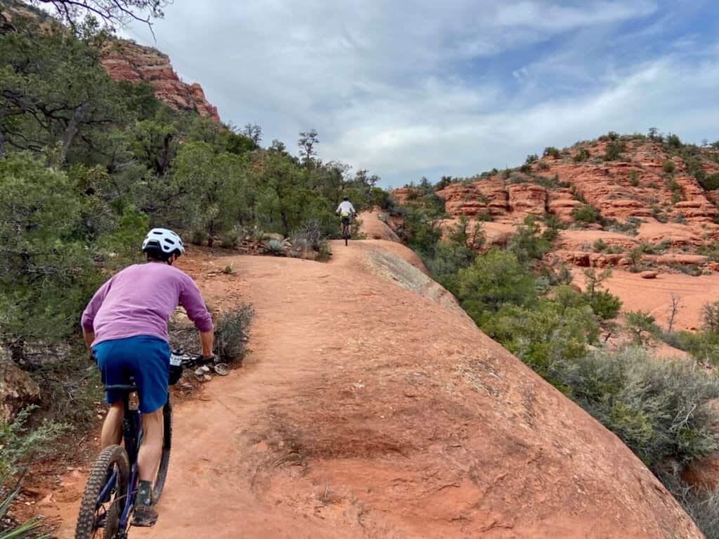 Mountain bikers on red slickrock section of trail in Sedona, Arizona