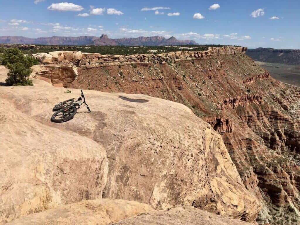 Mountain bike laying on huge rock slab on Gooseberry Mesa in Utah with steep cliff drop off on one side