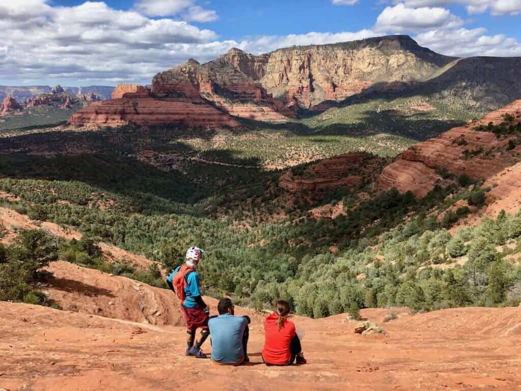 Mountain bikers looking out over views from top of rock slab saddle in Sedona