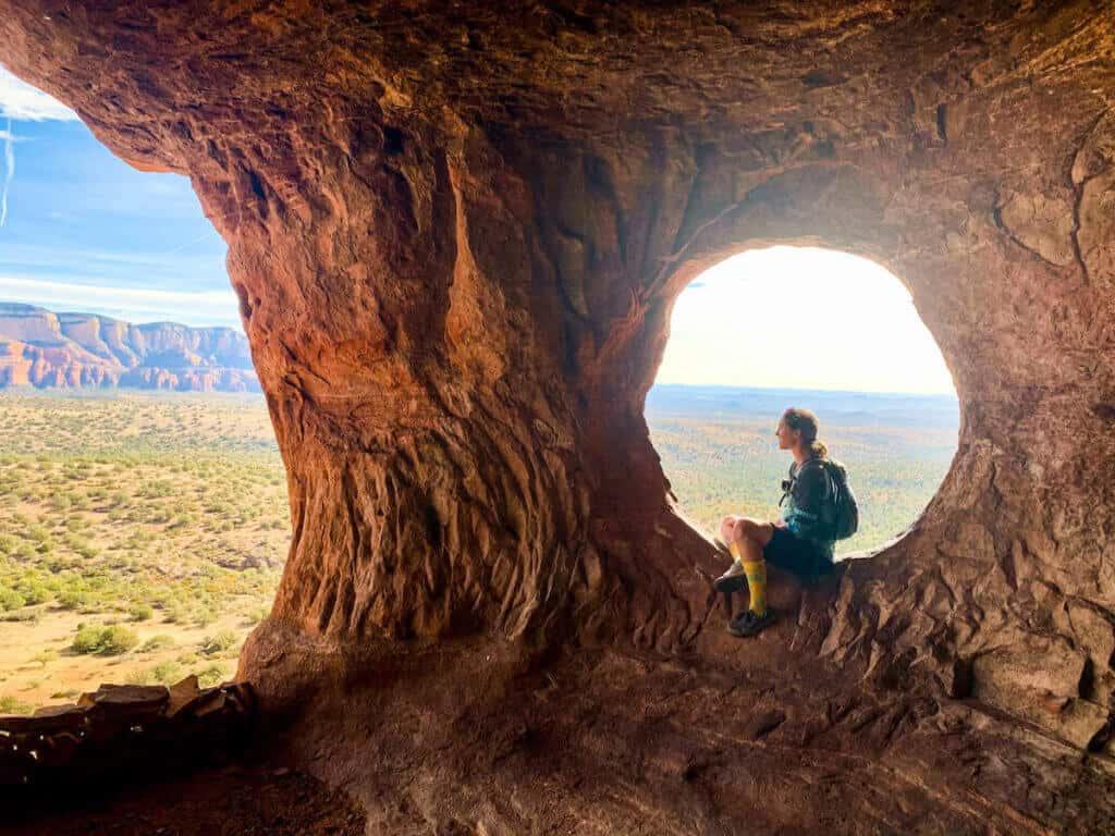 Becky sitting in perfect natural rock circle hole in Robbers Roost Cave in Sedaon