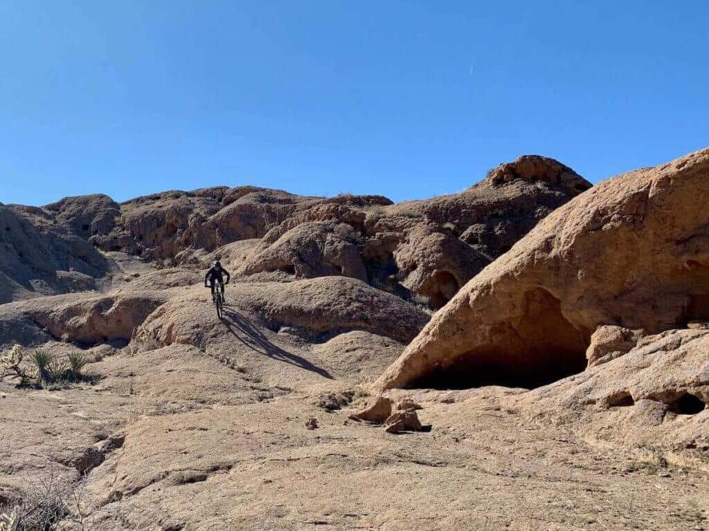 Mountain biker riding on rock slickrock slab on Monolith Garden Loop in Kingman Arizona