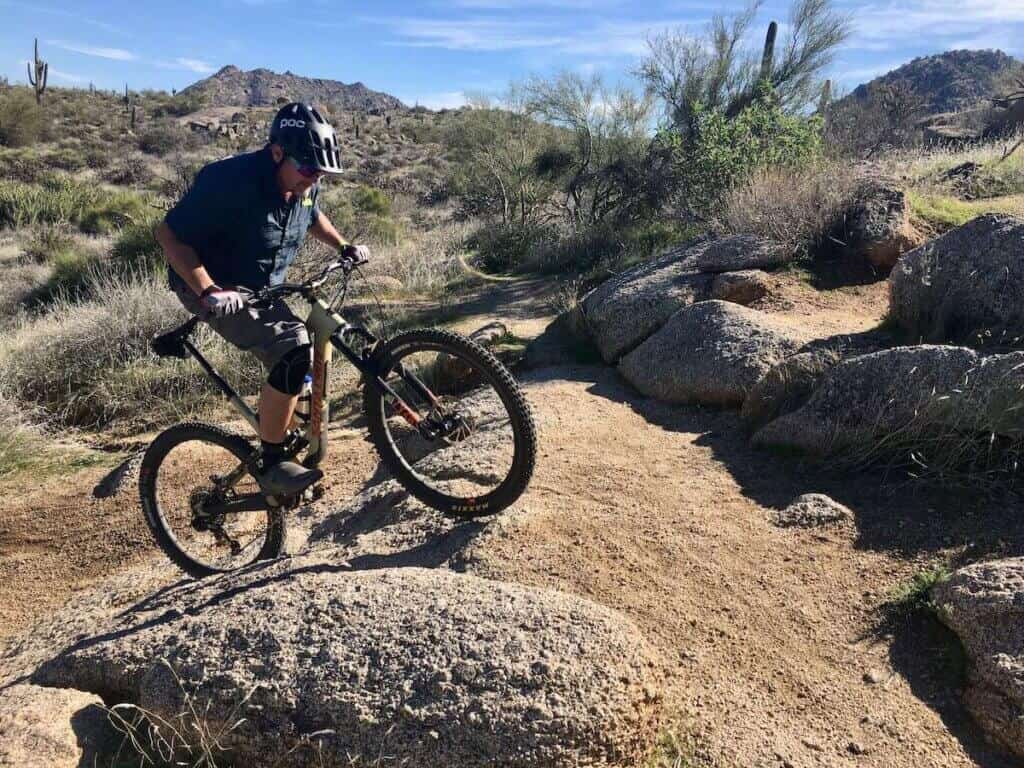 Mountain biker climbing up steep rock roller on trail in Phoenix, Arizona