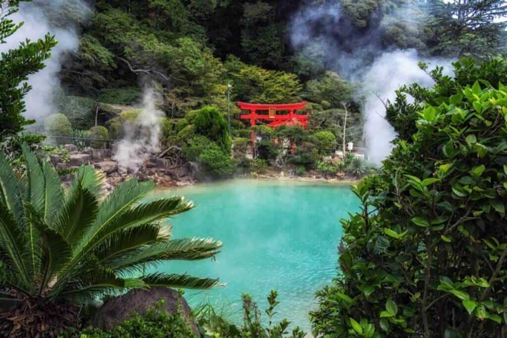 Hot spring thermal onsen in Japan surrounding by lush, green vegetation