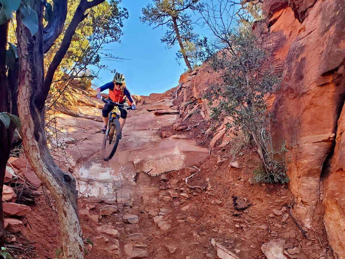 Mountain biker riding down narrow chute on Hiline Trail in Sedona, Arizona