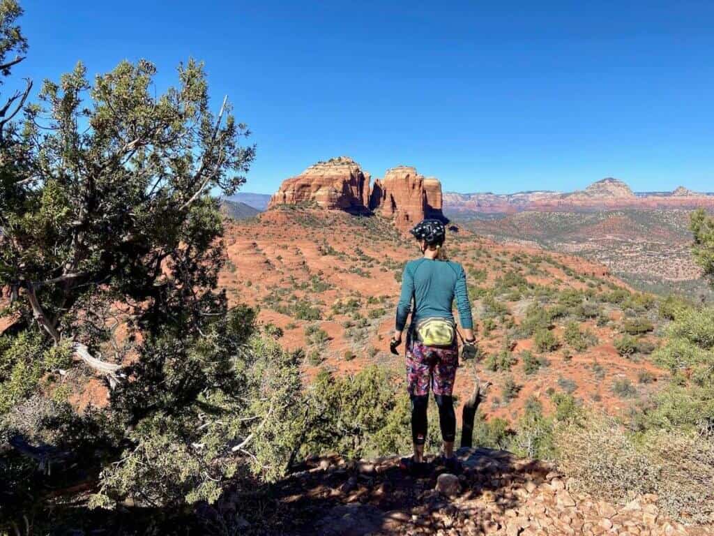 Mountain bike off bike looking out over beautiful views of Cathedral Rock in Sedona