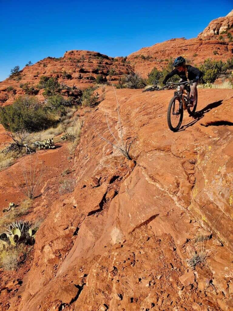 Mountain biker riding down steep rock section of trail on Hiline in Sedona