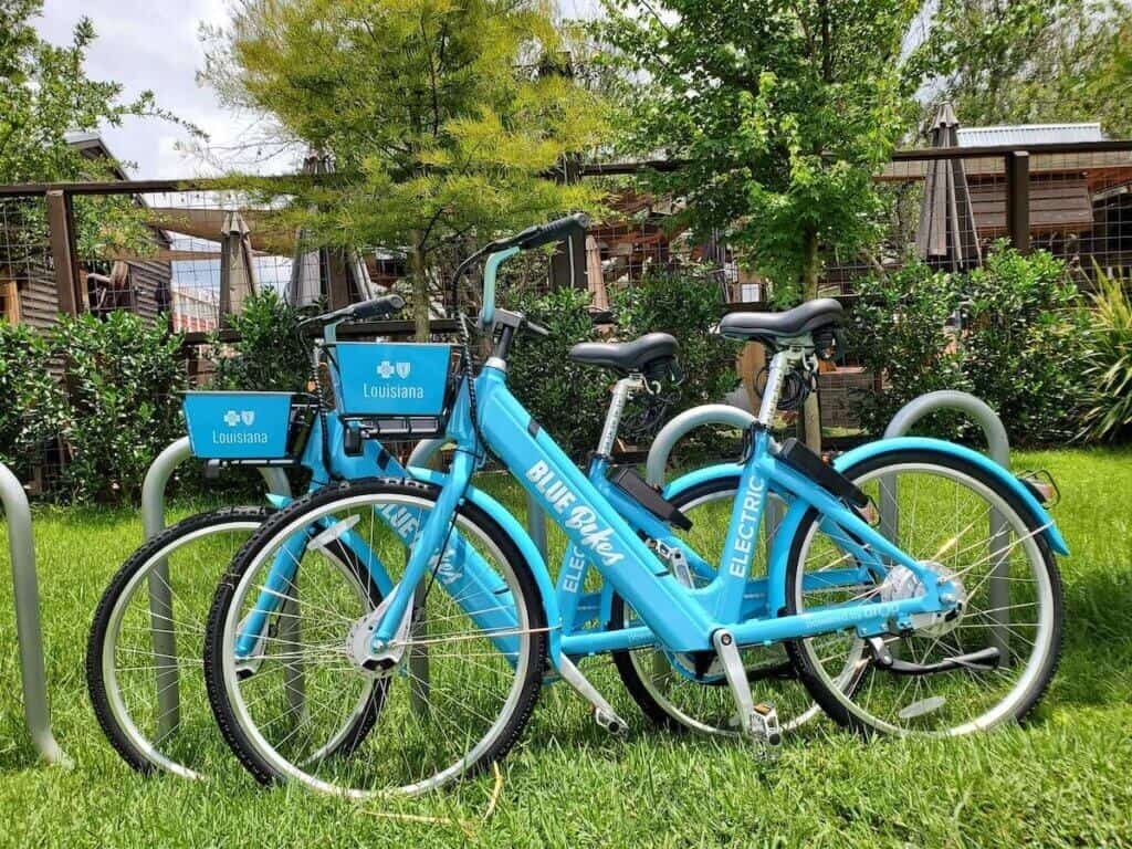 Two blue electric Blue Bikes Nola standing side by side