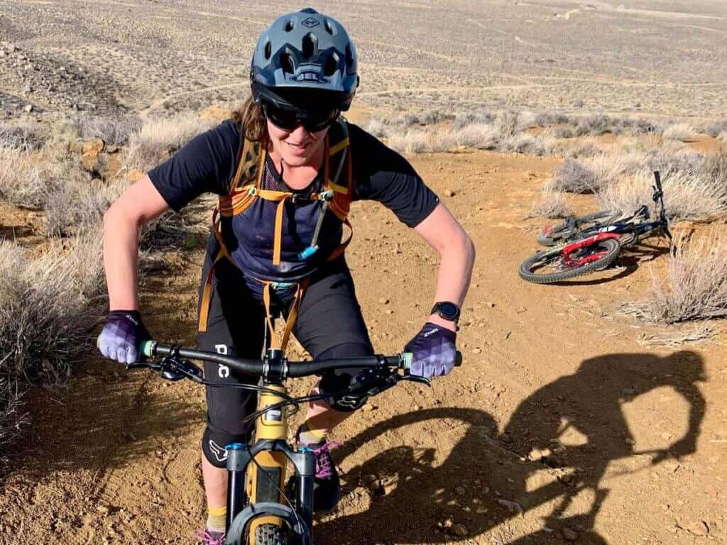 Becky riding mountain bike toward camera wear Garmin Fenix watch on left wrist