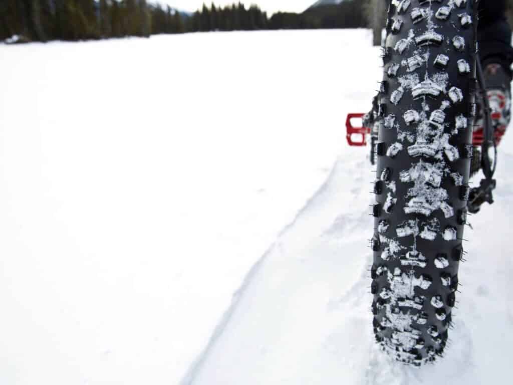 Rear tire of fat bike rolling over snowy trail