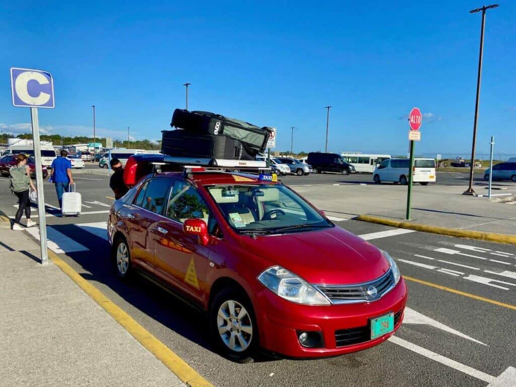 Car with two bike bags strapped to the top at airport in Costa Rica