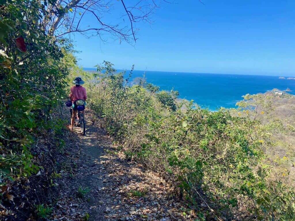 Bikepacking stopped on trail in Costa Rica looking out over ocean views
