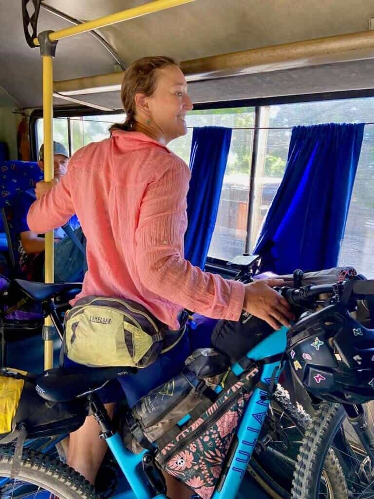 Woman standing next to loaded bikepacking bikes on bus in Costa Rica