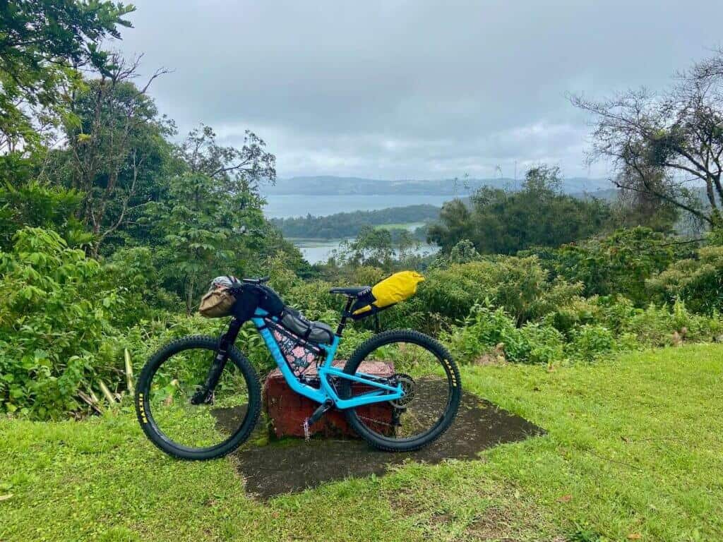 Bike loaded with bikepacking bags propped up at scenic overlook in Costa Rica