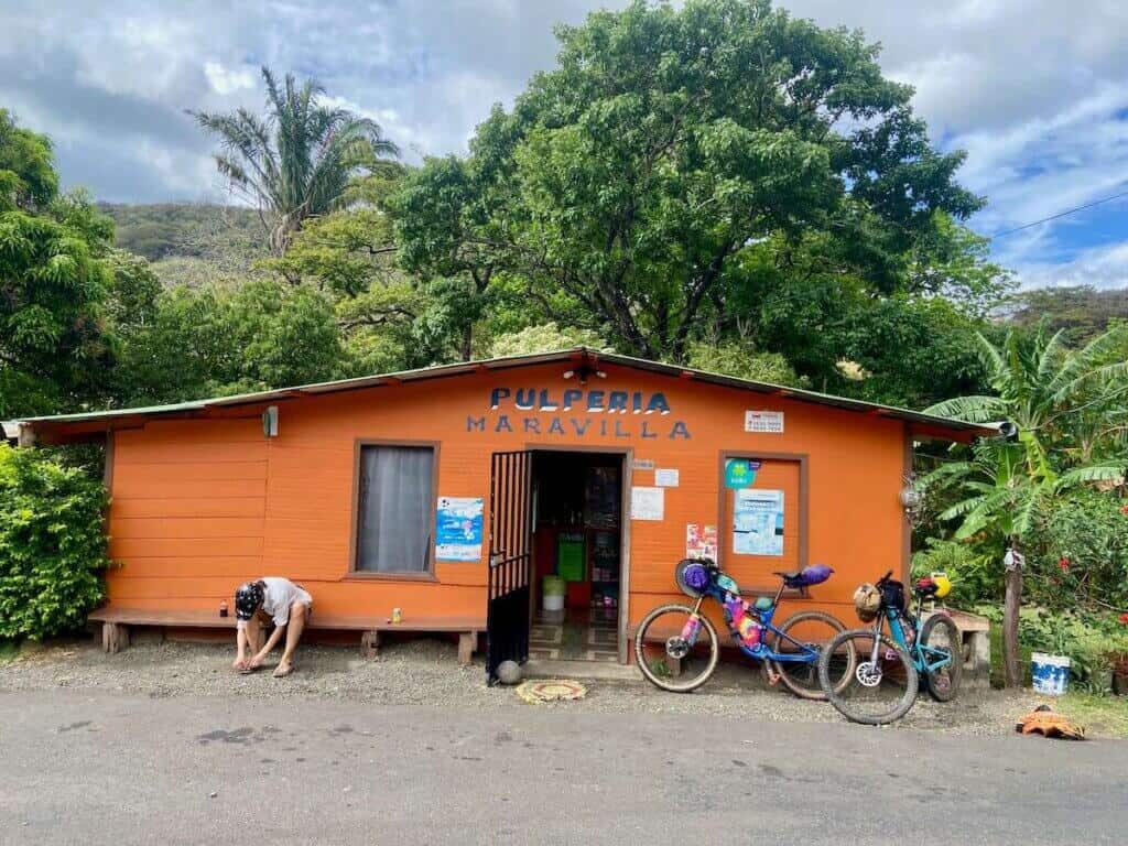 Small store in rural Costa Rica with two bikepacking bikes and white female oustide