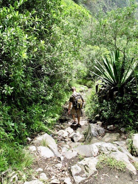 Man hiking down steep rocky trail outside of Baños Ecuador
