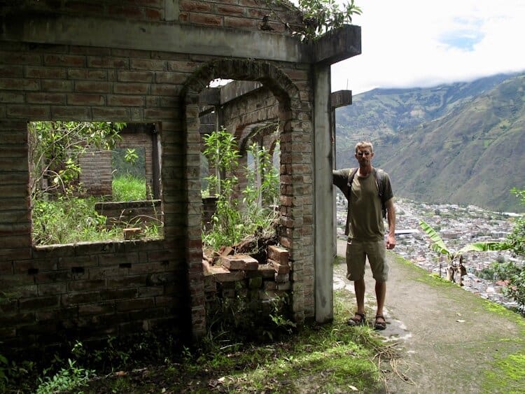 Man standing next to ruins on hike outside of Baños Ecuador