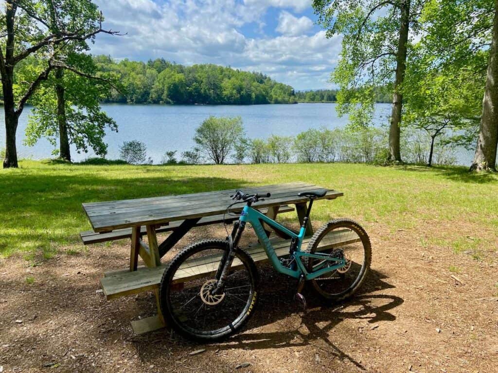 Mountain bike leaning against picnic table in front of lake in DuPont State Forest in North Carolina