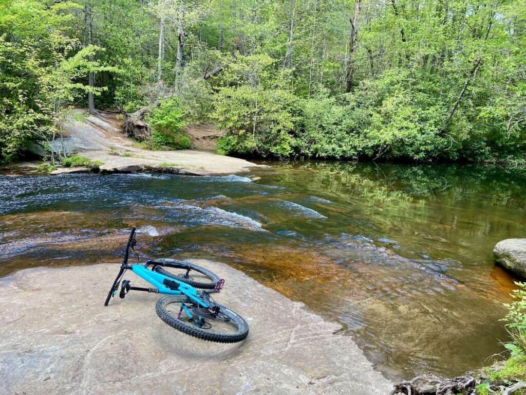 Mountain bike laying on rock slab next to river in DuPont State Forest near Brevard North Carolina
