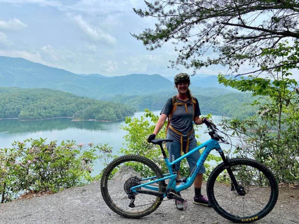 Becky standing behind Juliana Joplin mountain bike at scenic overlook onto Fontana Lake in Tsali Recreation Area in North Carolina