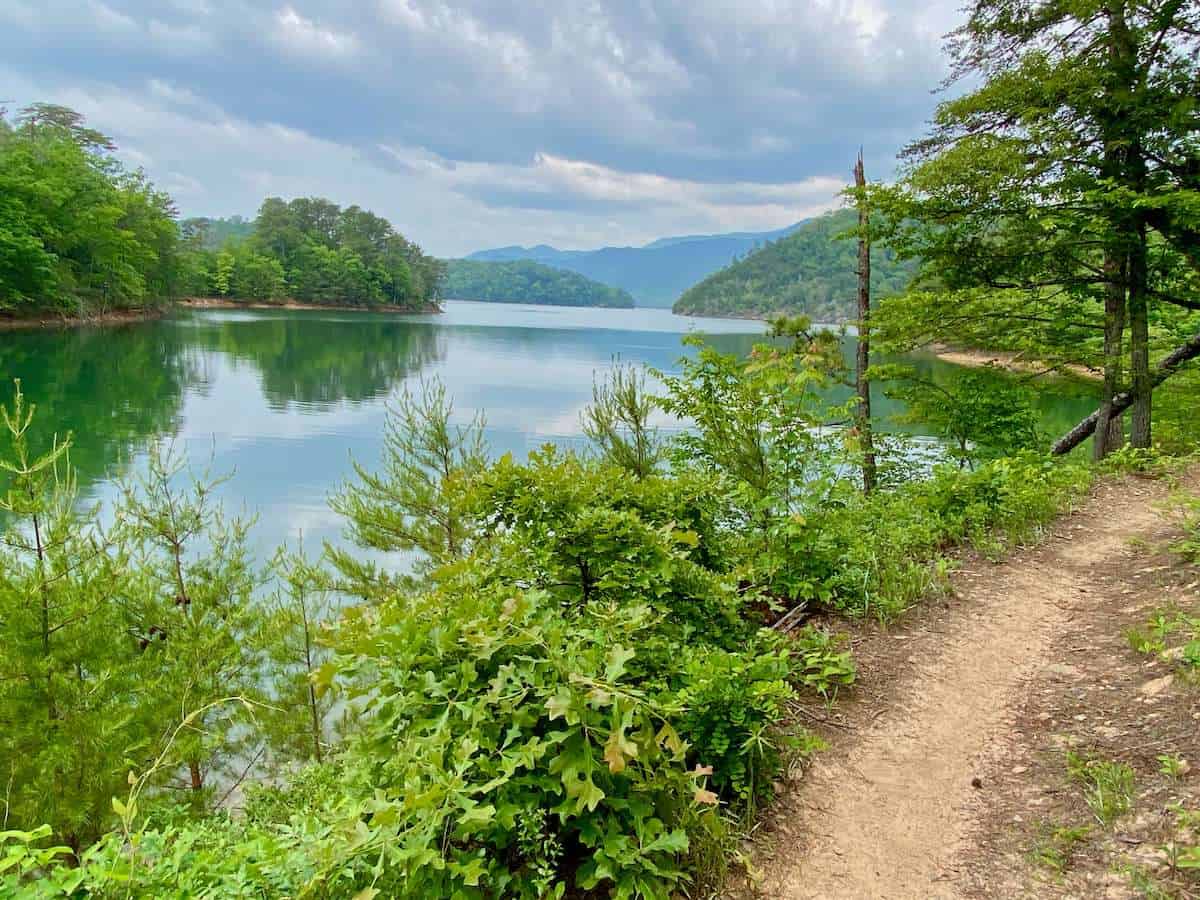 Landscape photo of singletrack mountain bike trail next to scenic lake in Tsali Recreation Area in North Carolina