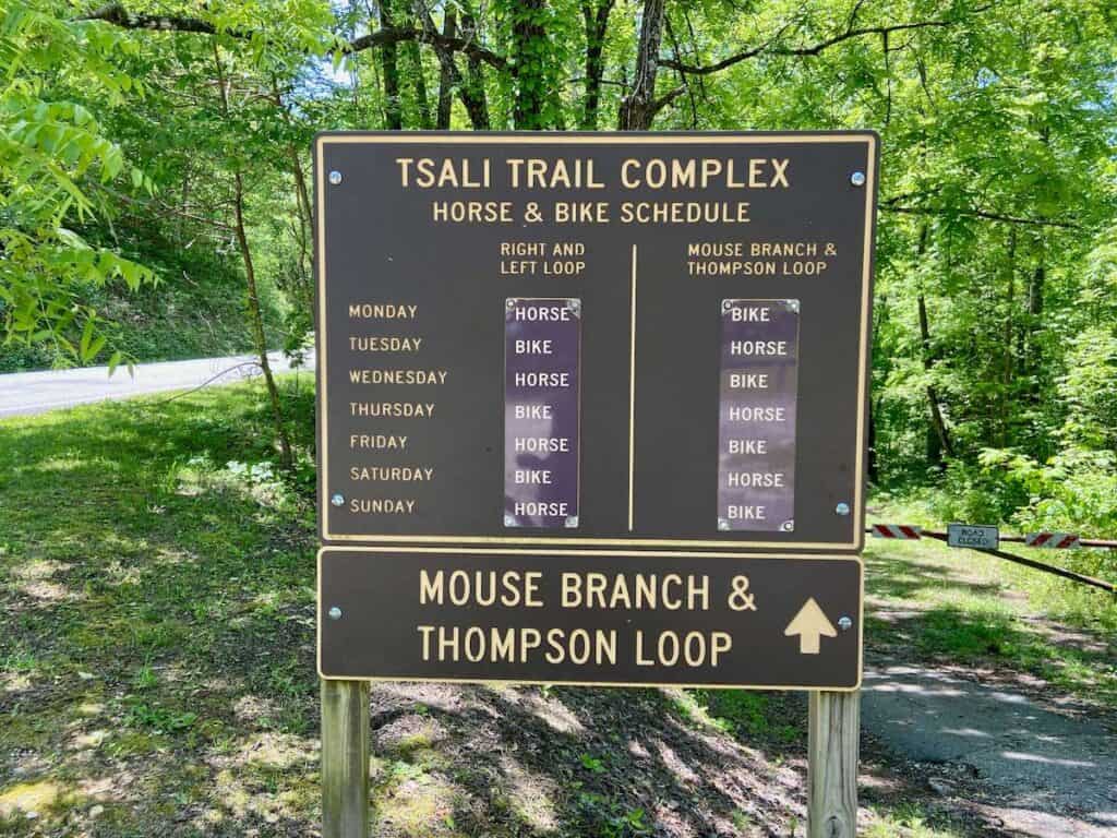 Trail sign at Tsali trail complex in North Carolina showing the trail schedule for bikes and horses broken into months and days of the week