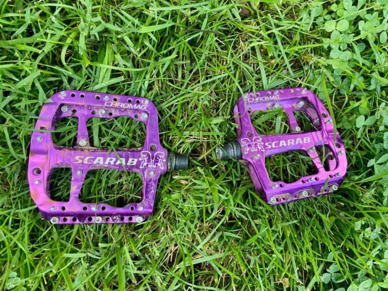 Two Chromag Scarab mountain bike pedals lying on grass