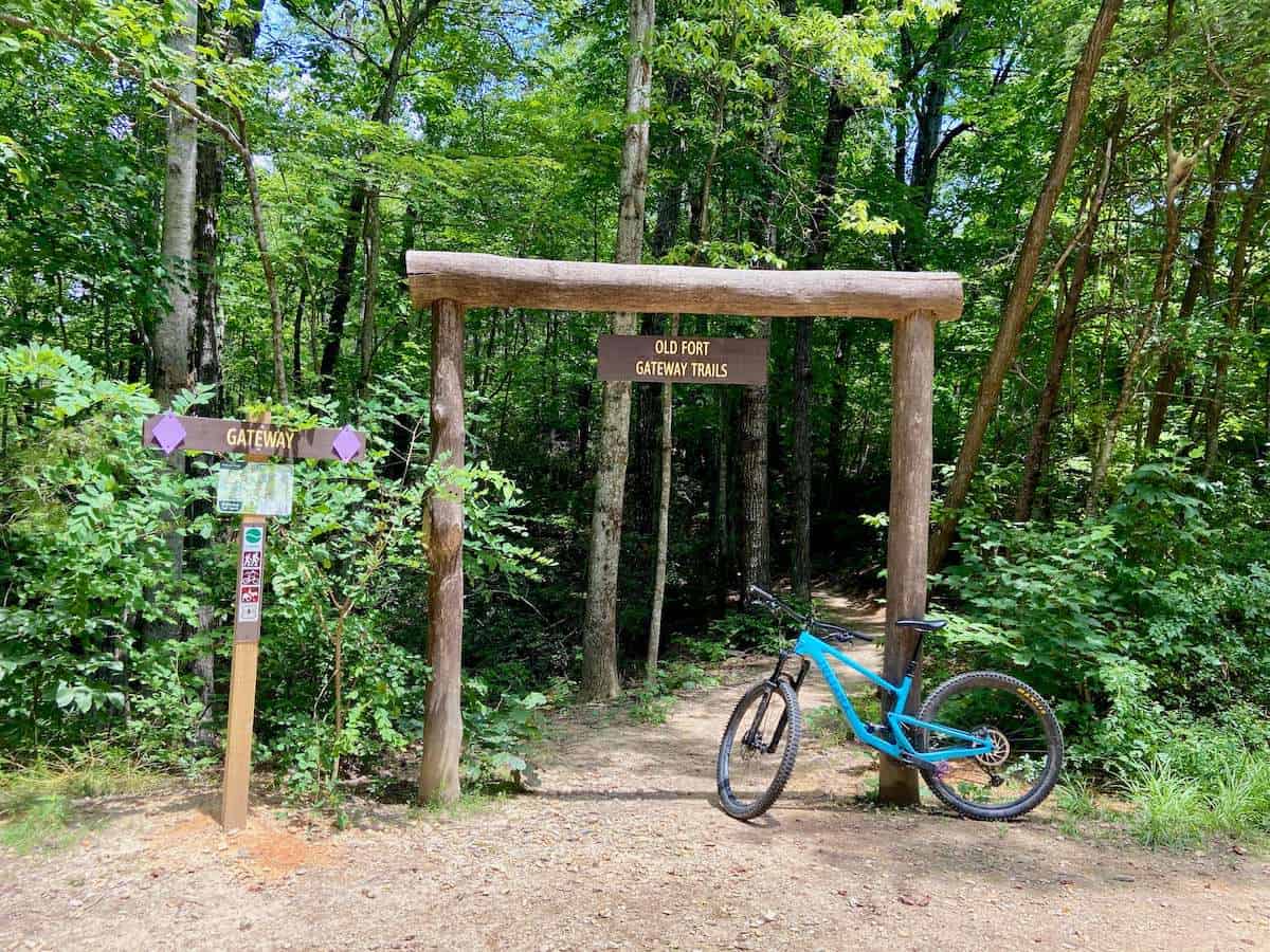 Mountain bike leaning against trail entrance post with Old Fort Gateway Trail signs