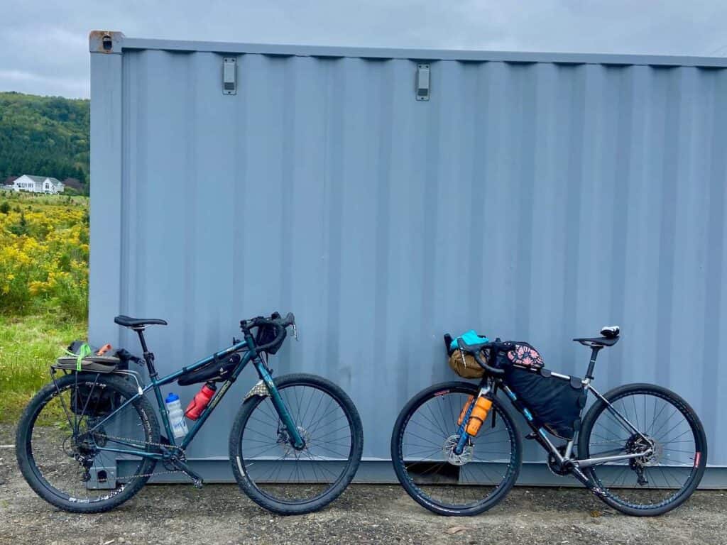 Two loaded bikepacking bikes leaning against shipping container at the start of the VTXL bike route that travels the length of Vermont