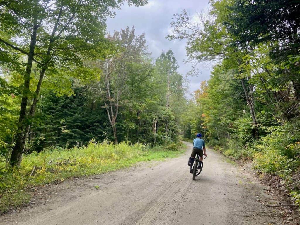 Man riding gravel bike down road on the VTXL bikepacking route that runs the length of Vermont