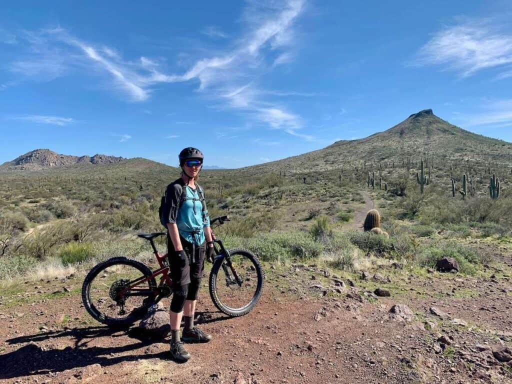 Mountain biker standing next to bike in front of Brown's Mountain outside of Phoenix, Arizona