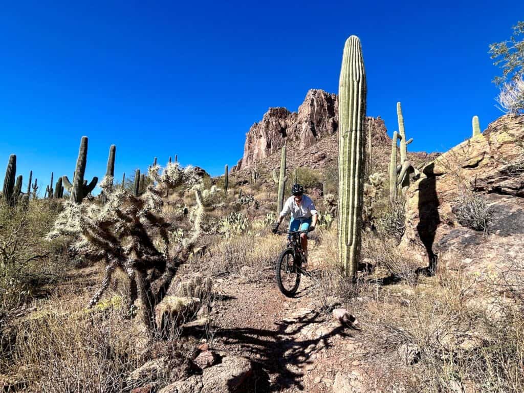 Woman riding mountain bike on desert trail at Gold Canyon near Phoenix, Arizona