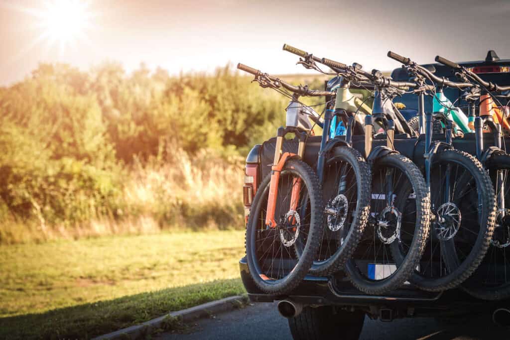 mountain bikes with front wheel over tailgate on pickup truck using a tailgate bike pad