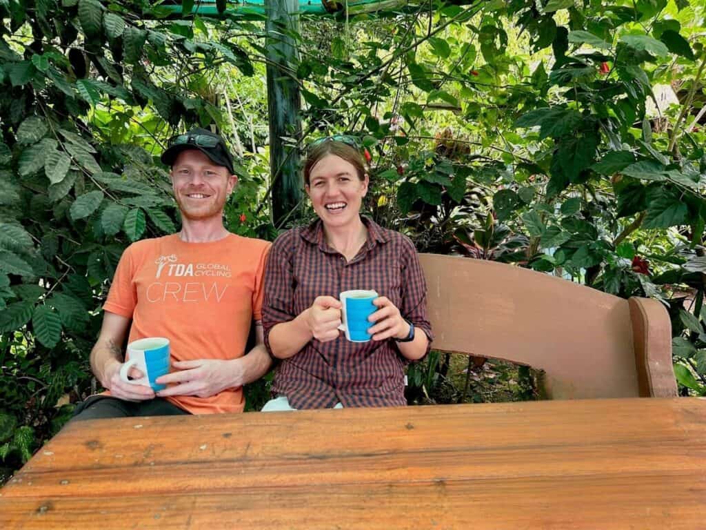 Two people sitting at table with blue coffee mugs in their hands
