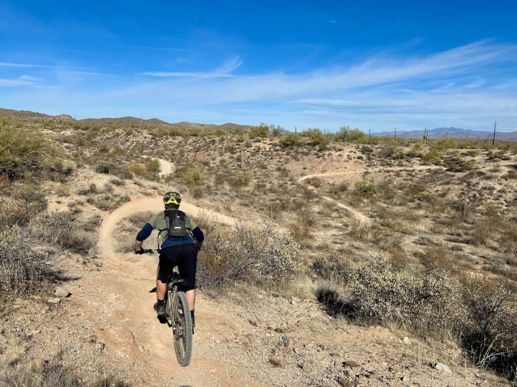Mountain biker riding bike on desert trail in McDowell Mountain Regional Park in Phoenix