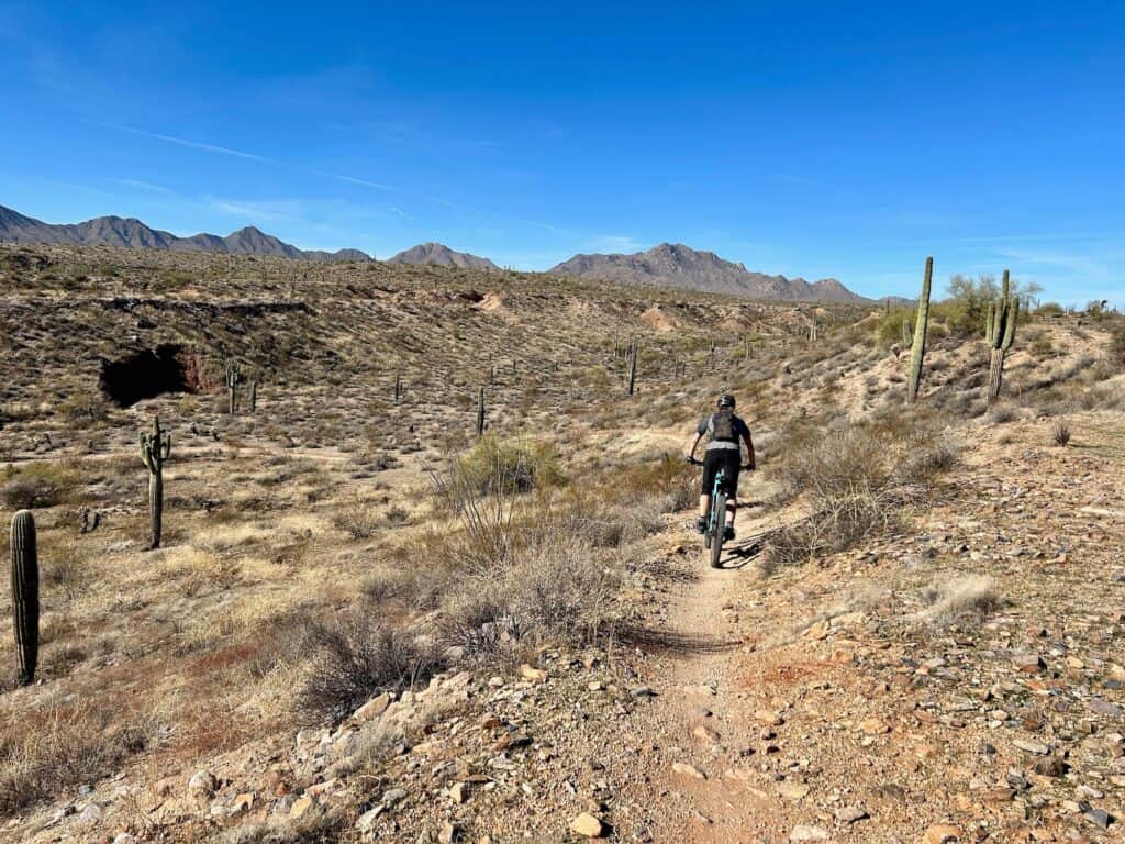 Mountain biker riding bike on desert trail at McDowell Mountain Regional Park in Phoenix