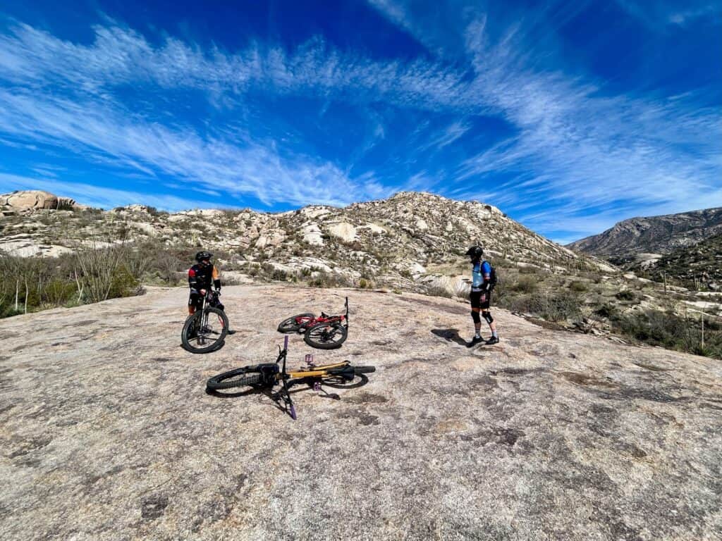 Mountain bikers taking a break on rock slab section of trail at Catalina State Park in Tucson