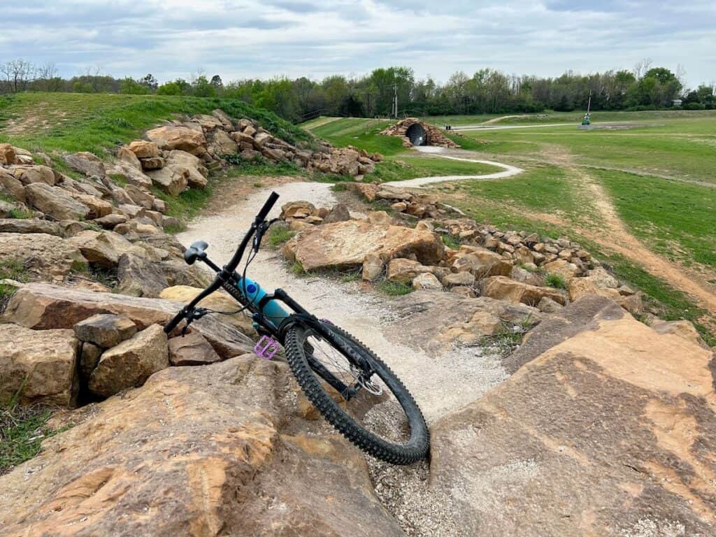 Mountain bike leaning against rock pile at starting 'hub' at Centennial Park in Fayetteville, Arkansas