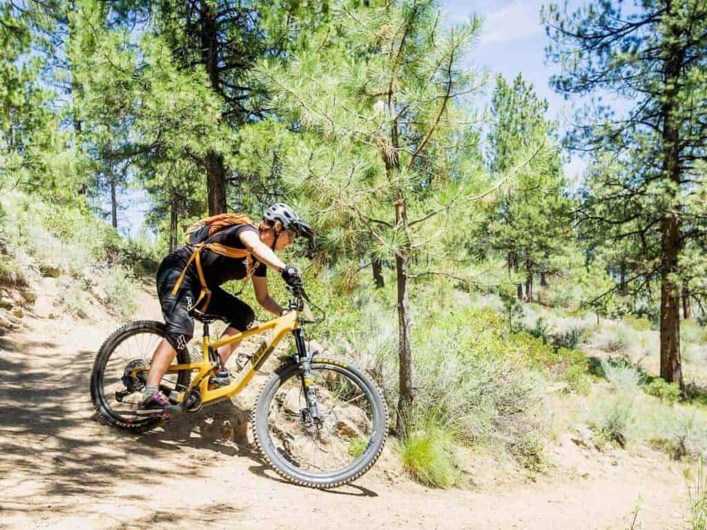 Becky riding mountain bike around tight switchback corner