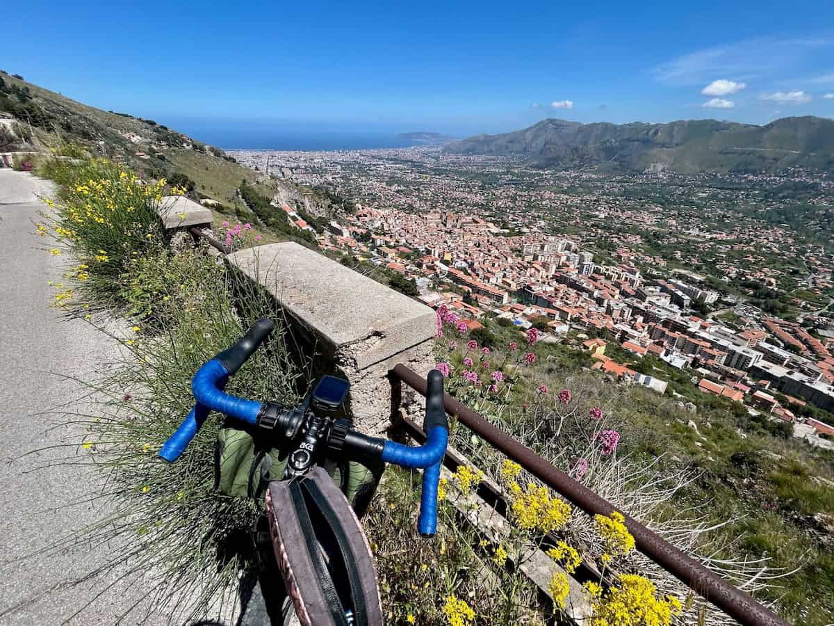 View out over front of road bike handlebars onto coastal town 