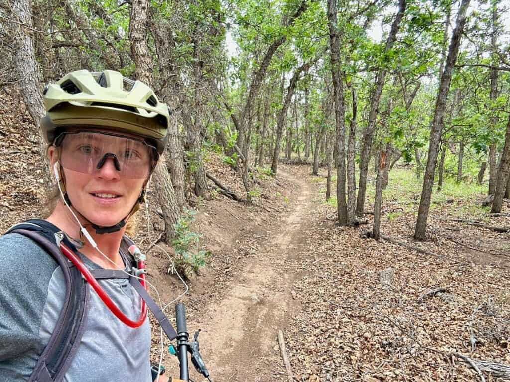 Female mountain biker taking a selfie in a oak grove