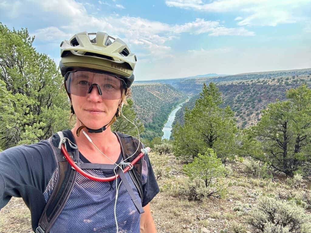 Woman taking a selfie in front of scenic view of river running through canyon