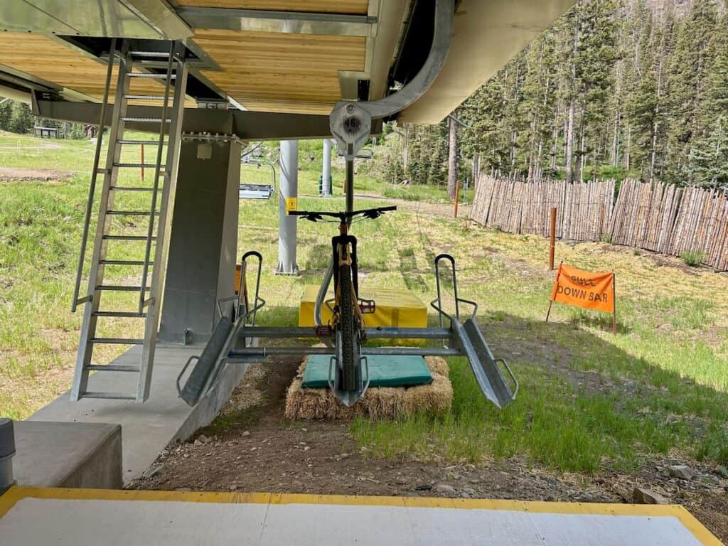 Mountain bike loaded onto bike tray on chairlift