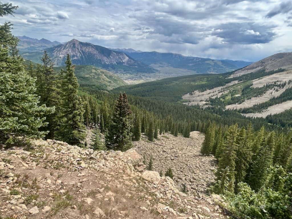 a mountain landscape with trees and mountains in the background