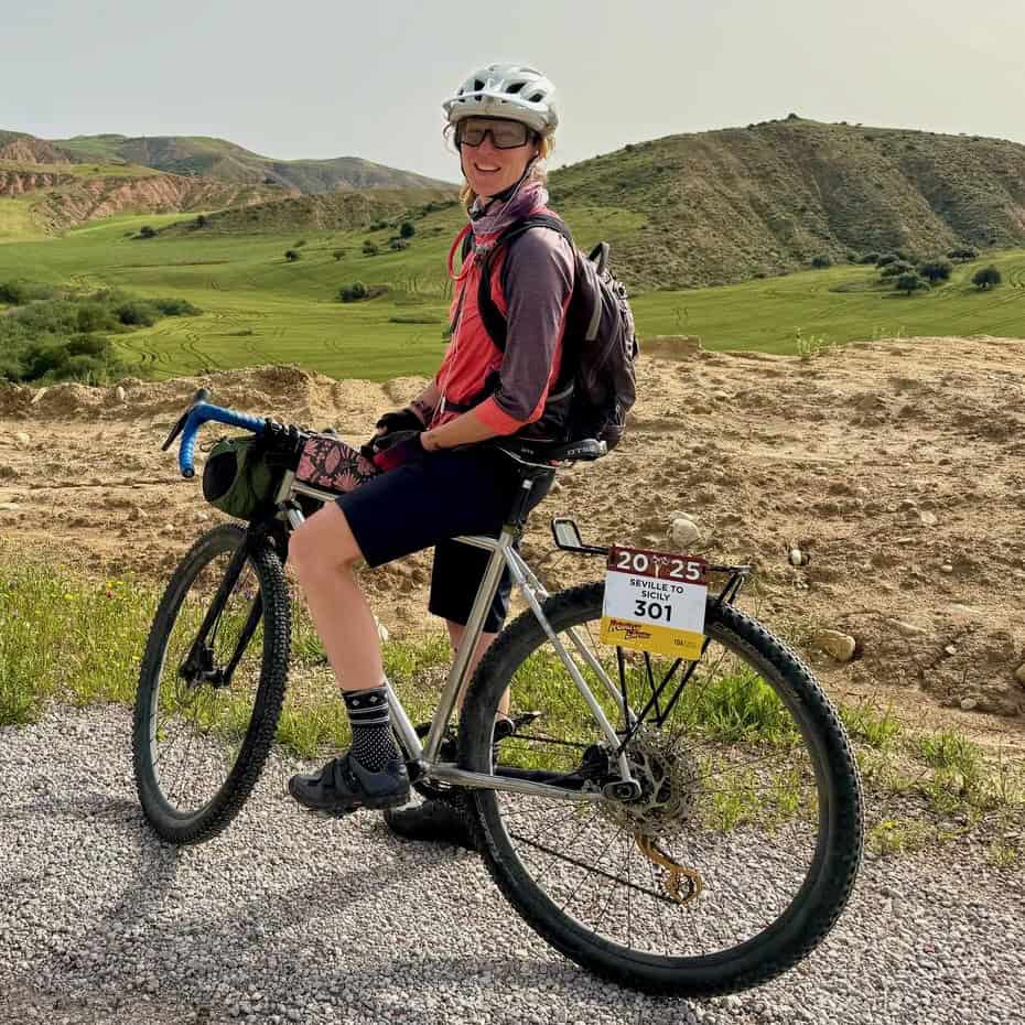 Woman sitting on bike smiling for photo