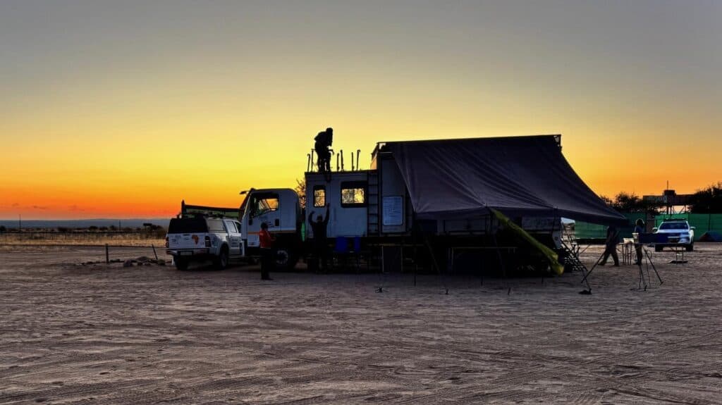 Person on top of large overland truck at sunrise
